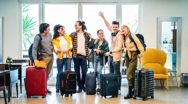Young group of tourists with suitcases arriving at youth hostel guest house - Happy friends enjoying summer vacation together - Millenial people doing check-in at hotel lobby - Summertime holidays