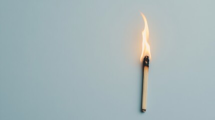 Lit matchstick on light blue background.
