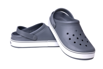 Pair of grey and white clogs resting on transparent background
