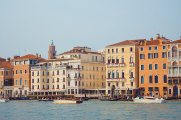 A picturesque view of Venice's vibrant waterfront showcasing historic colorful buildings, gondolas, and water taxis along the canal. Perfect for travel, culture, and urban photography themes. 