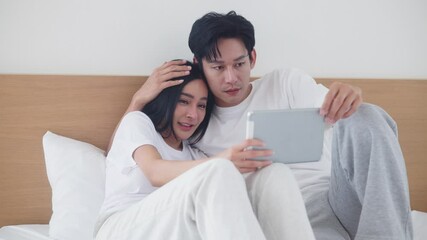 Happy couple watching movies and dramas on the bed