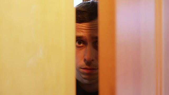 Man opening the door with a hostile expression.