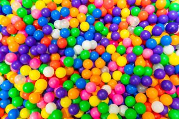 A vibrant and colorful ball pit filled with bright multicolor plastic balls.