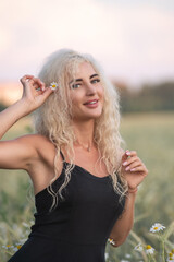 Naklejka premium Portrait of a young beautiful blonde girl in nature in summer.
