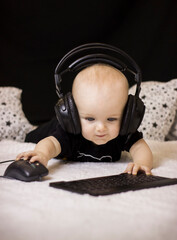 
A child wearing headphones with a computer