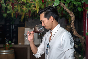 Japanese wine tester man smelling wine from glass during testing wine products in winery factory
