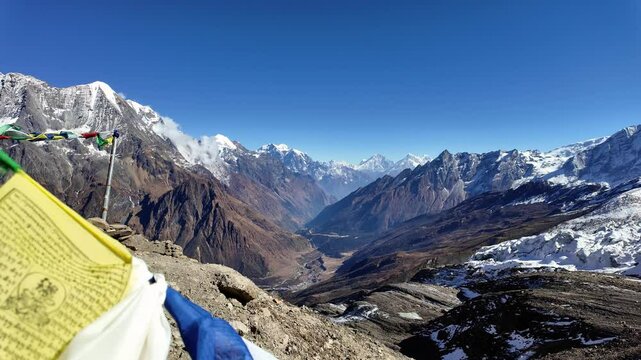 Manaslu Base camp, Nepal - November 24 2024: Tibetan prayer flags fly above the valley along the Manaslu circuit and the Sama village in the Himalaya on a sunny winter day in Nepal