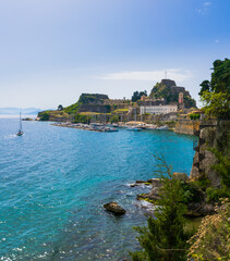 Vertical panoramic view of the Old Fortress of Corfu with descending iron staircase and sailboat on...