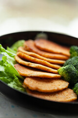 Golden-brown pancakes served with a side of steamed broccoli and fresh lettuce.