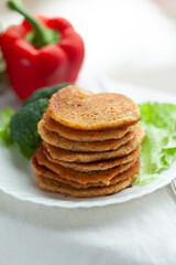 A stack of savory pancakes served with fresh vegetables.  A healthy and delicious meal.