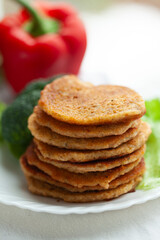 A stack of savory pancakes, perfect for a healthy and delicious meal.  Served alongside fresh vegetables.