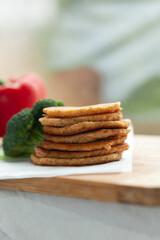 Stack of healthy pancakes with broccoli and bell pepper.