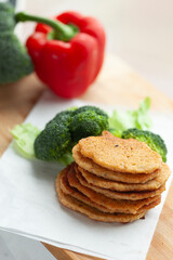 Stack of savory vegetable fritters with fresh broccoli and bell pepper.