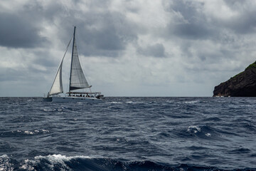  A sailboat cruising toward the Coin de Mire island . The island forms part of the territory of Mauritius
