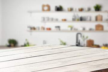 Empty wooden table in a bright, modern kitchen. Ideal for showcasing products or recipes.