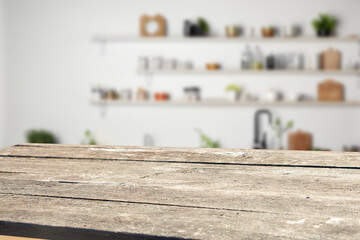 Fototapeta premium Rustic wooden table top in a bright kitchen setting. Ideal for product displays or food photography.