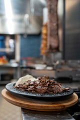 Turkish meat doner being prepared in a restaurant kitchen