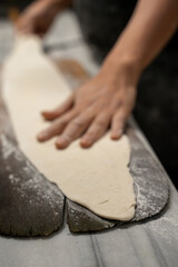 Baker kneading bread dough in the kitchen