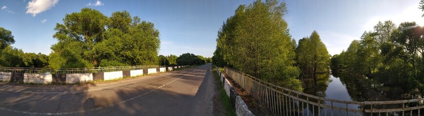 Panoramic view of old bridge over small river in countryside