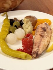 Mediterranean pickled vegetables and fish platter with lemon wedge