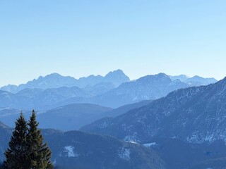 Obraz premium Panoramic view of snow-capped mountain peaks under blue sky