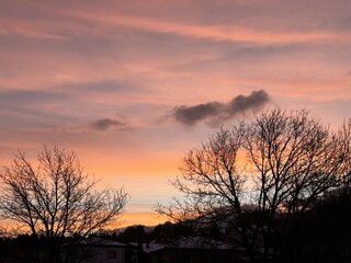 Vibrant winter sunset over snowy landscape with bare trees