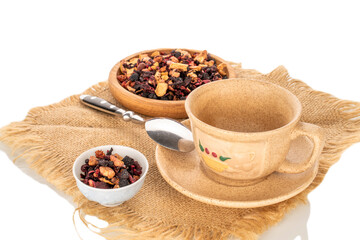 Carpathian forest fragrant tea with ceramic dishes on a jute napkin, close-up, isolated on a white...