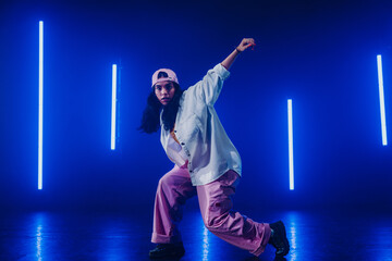 Hip hop dancer dancing in a cool studio with neon lights.