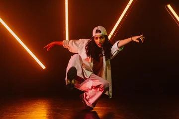 Fotobehang Hip hop dancer dancing in a cool studio with neon lights. © oneinchpunch