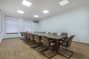 Office meeting room in a modern corporate building. A long table and comfortable chairs.