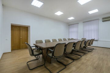 A special room for business meetings and negotiations in a modern office. A long table with chairs.