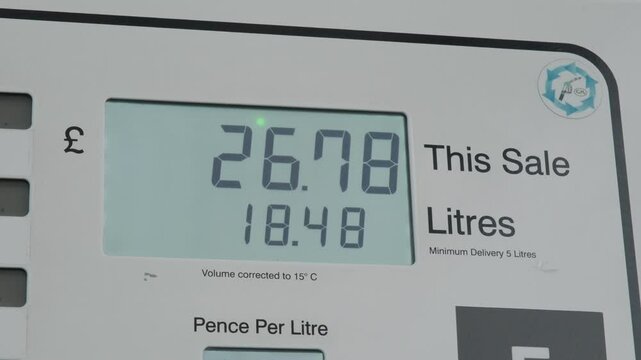 Price of fuel going up as person fills car with petrol in the UK.