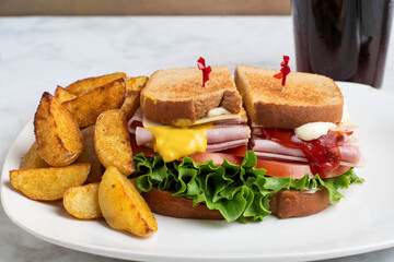 ham sandwich with potato  wedges and soft drinks