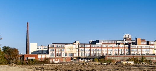 A large brick building with a tall chimney
