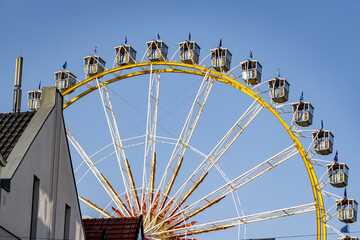 A large Ferris wheel with a yellow and white color scheme