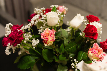 Close-up of a beautiful bouquet featuring various rose colors and baby's breath. The roses are arranged to showcase their vibrant hues and delicate textures.