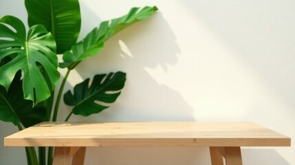 Serene Minimalist Setting Light Wood Table with Lush Tropical Foliage Against a Neutral Wall
