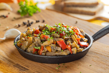 Sautéed mushrooms with peppers and herbs in a cast iron pan.