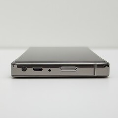 A black mobile device with a dual camera and a port for charging