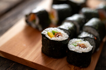 Fresh sushi rolls on wooden board