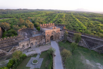Fototapeta premium Aerial view of ruins of Rohtas fort Pakistan, The main gate outpost and watch tower on green hill.