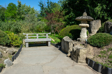 A Japanese garden full of stones and bonsai bushes. A peaceful and well-maintained park in the Asian style.