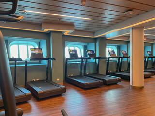 Moderne Fitnessgeräte und Kraftmaschinen in Sportstudio auf Kreuzfahrtschiff - Modern cardio and weight equipment in fitness center gym onboard cruiseship cruise ship ocean liner