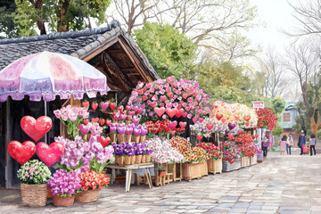 vibrant flower market filled with colorful blooms and heart shaped decorations, creating cheerful atmosphere. Visitors enjoy beauty of floral displays