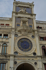 The astronomical clock located in Venice, Italy displays the time, zodiac signs, and planetary positions. Visitors marvel at its complex mechanisms and beautiful blue and gold façade.