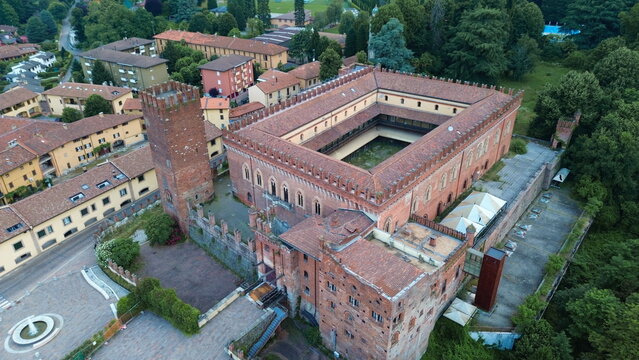 aerial view about Carimate Castle surrounded by green wild forest in sunrise lights