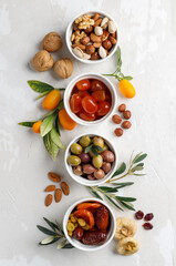Mix of dry fruits and nuts, branch with young green leaves. Concept of the Jewish holiday Tu Bishvat