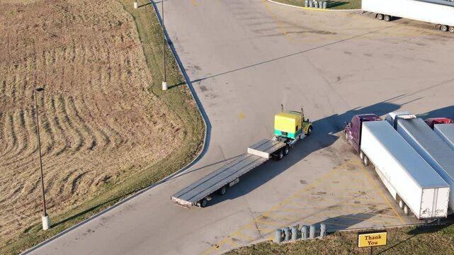 Aerial view of the truck with step deck trailer is moving on truck stop. Top down view
