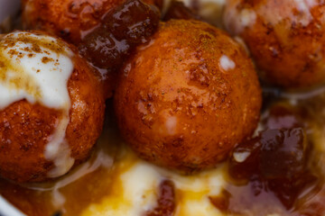 round spherical donuts with sweet caramel syrup street food close up