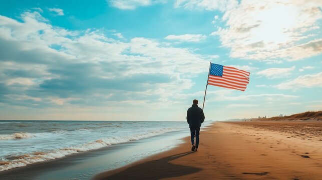 Back view of a person walking along a beach with an American flag trailing behind them